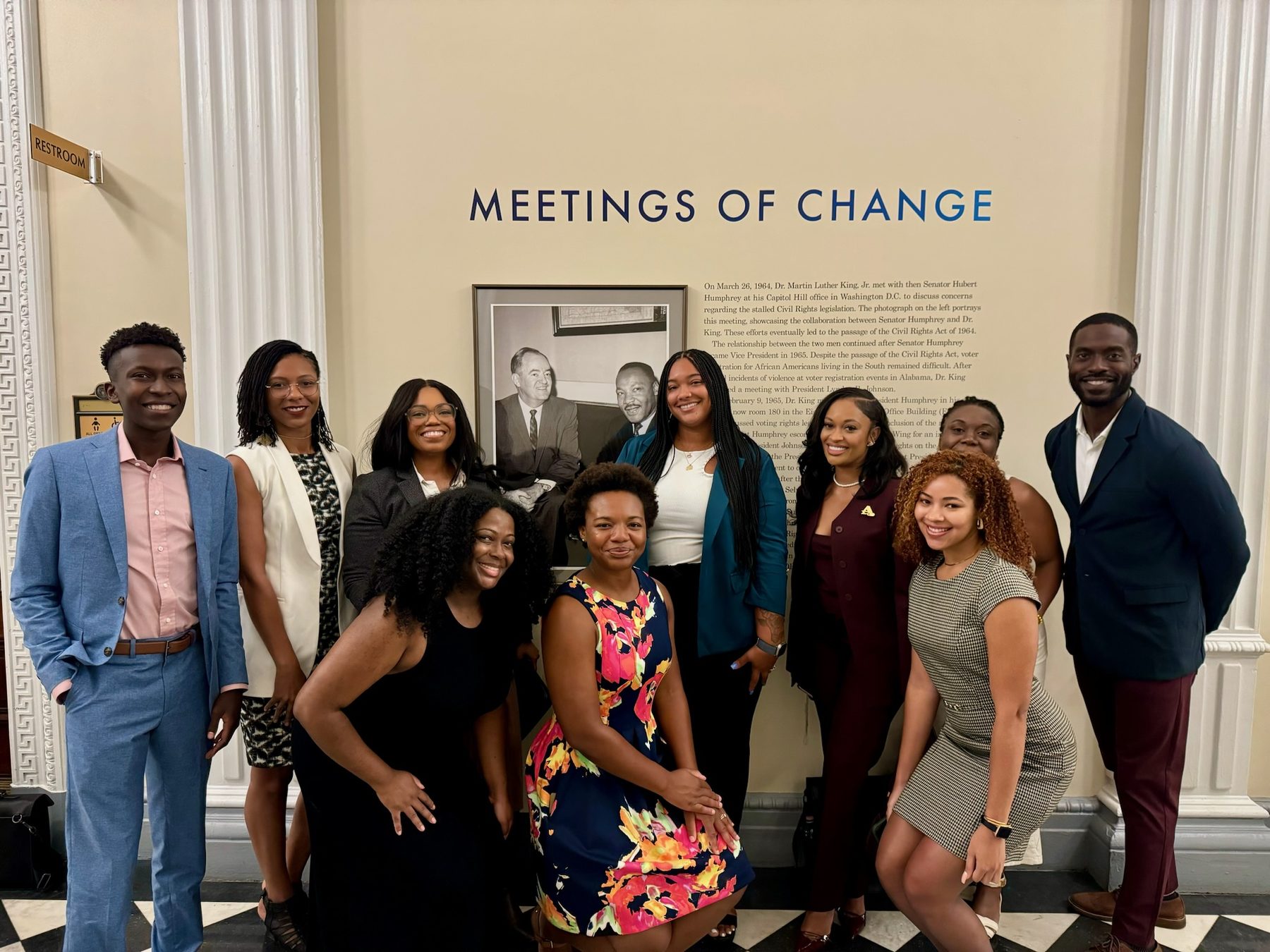 Members of the Critical Policy Collective at the U.S. Capitol, standing before the Meetings of Change display commemorating Dr. Martin Luther King Jr.'s 1964 meeting with Senator Hubert Humphrey.